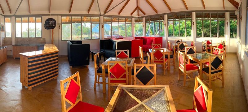 Bright dining room with red chairs and wooden tables