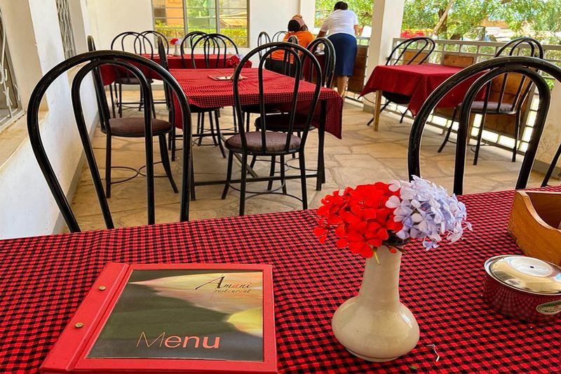 Restaurant tables with red checked cloths and a menu