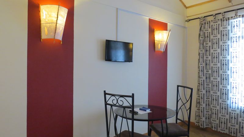 Room corner with wall lights, a television and a small table