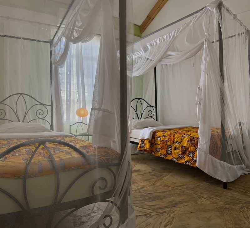 Room with canopy nets and orange patterned bedding